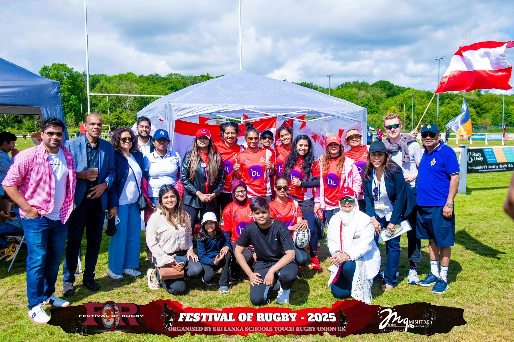 Rugby team and supporters gathered by a tent at Festival of Rugby 2025